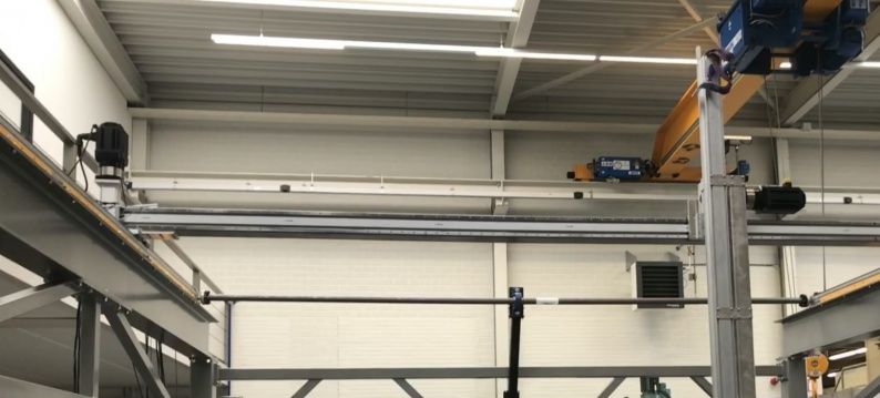 Portal robot with a working range of 7600 x 400 x 2500 mm in the X-Y-Z plane where solar panels are stacked.